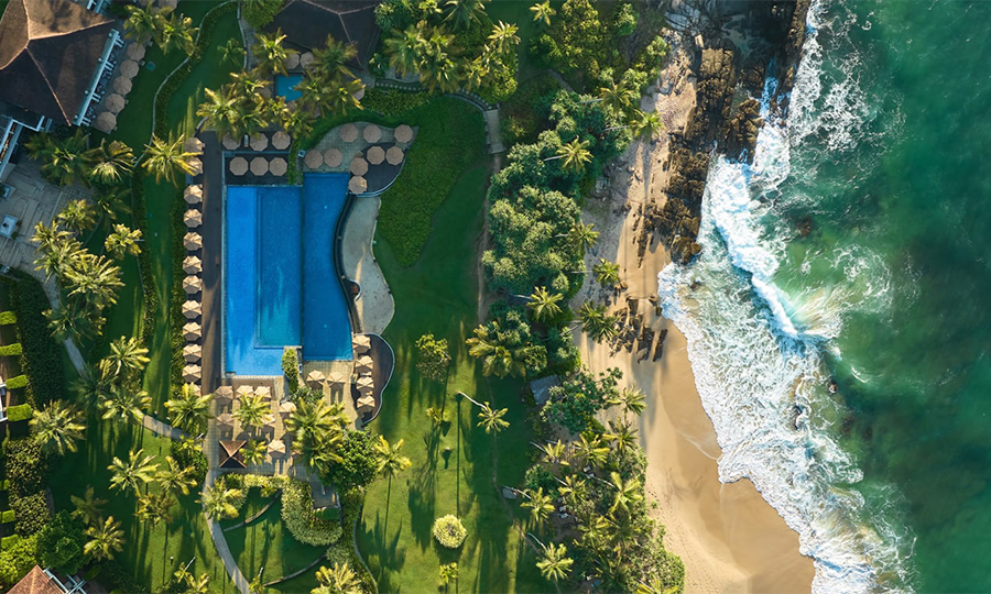 Aerial view of Anantara Peace Haven Tangalle, a luxury beachfront resort surrounded by lush greenery and golden sands.